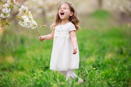 Nervous child girl in blossom gardenの写真素材