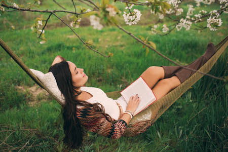 Woman is relaxing in hammock on the natureの写真素材