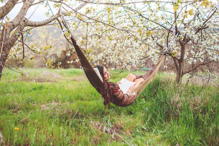 Woman is relaxing in hammock on the natureの写真素材