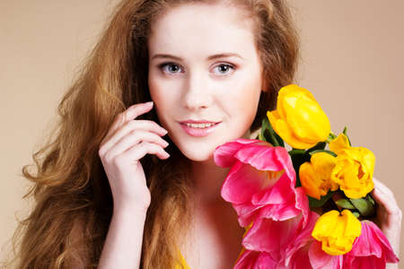 Beautiful redheared girl with tulipsの写真素材