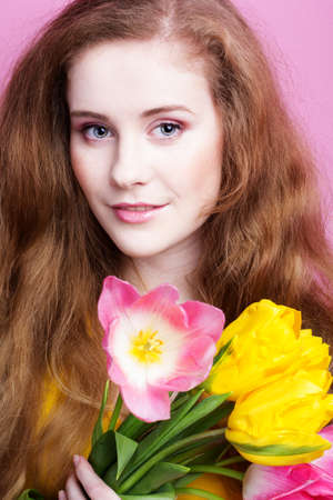 Beautiful redheaded girl with tulipsの写真素材