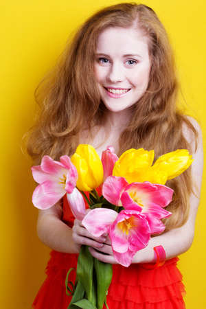 Beautiful redheaded girl with tulipsの写真素材