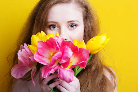 Beautiful redheaded girl with tulipsの写真素材