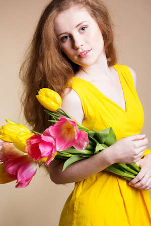 Beautiful redheaded girl with tulipsの写真素材