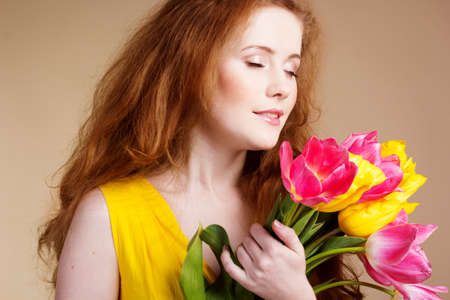 Beautiful redheaded girl with tulipsの写真素材
