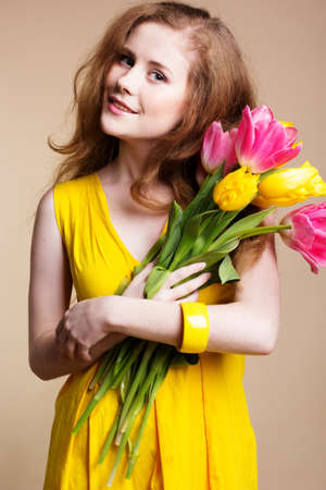 Beautiful redheaded girl with tulipsの写真素材