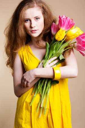 Beautiful redheaded girl with tulipsの写真素材