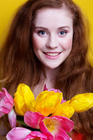 Beautiful redheaded girl with tulipsの写真素材