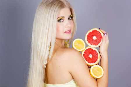Beautiful blonde girl with fruitsの写真素材