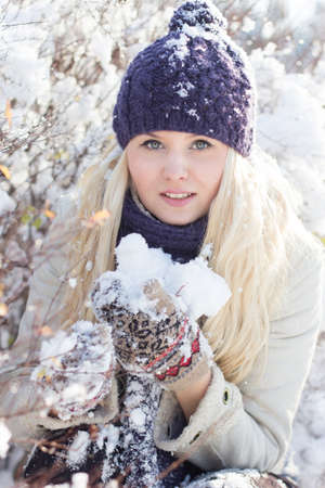 beautiful winter woman playing with snowの写真素材