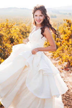 Bride wearing nice white dress is walking in a vineyard wedding time.の写真素材