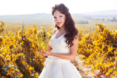 Bride wearing nice white dress is walking in a vineyard wedding time.の写真素材