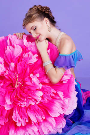Beautiful belly dancer girl with nice makeup and heardress with pink peony umbrella. Isolated on purpleの写真素材