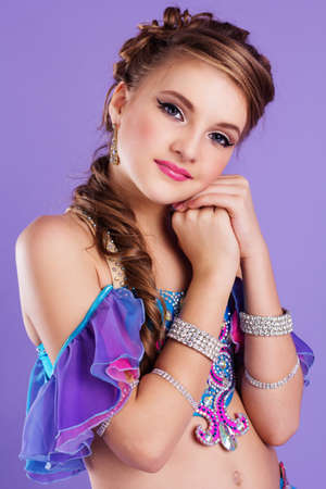 Beautiful belly dancer girl oriental fairy tale. Isolated on purpleの写真素材