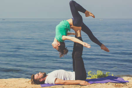 Couple practicing acroyoga in the morningの写真素材