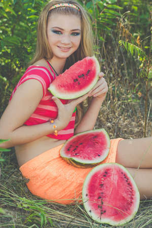 Beauty teenager girl eating watermelon outdoorsの写真素材