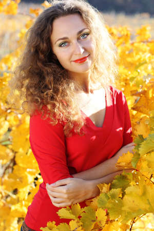 Portrait of beautiful girl with curly hair in yellow grape vineyardの写真素材