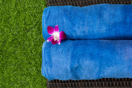 Two blue towels in spa with orchid flowerの写真素材