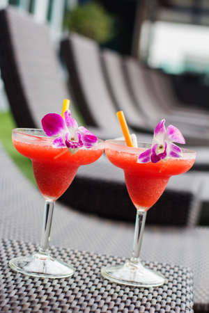 Frozen margarita with strawberry on wooden table