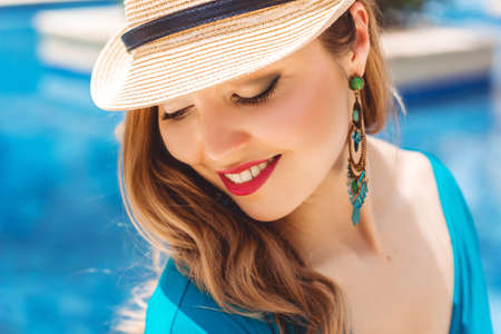 Fashion young woman near blue waterの写真素材