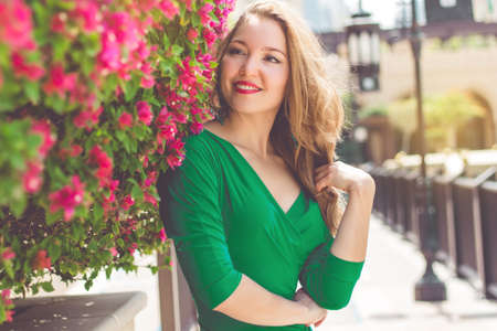Smiling young woman near blossom pink flowersの写真素材