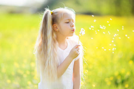 Little blonde girl with dandelion flowerの写真素材