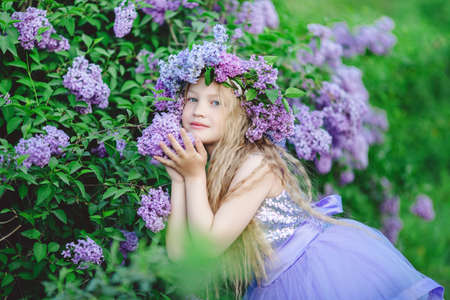 Beautiful child girl with wreath of lilac flowersの写真素材