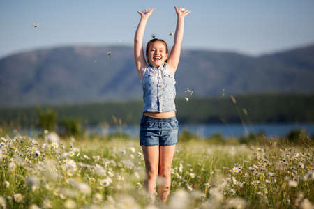 Pretty happy child girl at camomile fieldの写真素材