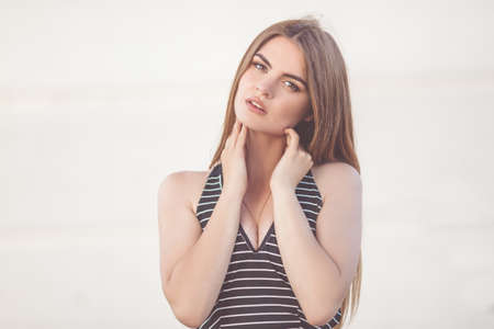 Closeup portrait of pretty young teen girl over white wall backgroundの写真素材