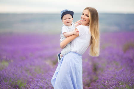 Happy mother and her little son having fun in a lavender fieldの写真素材