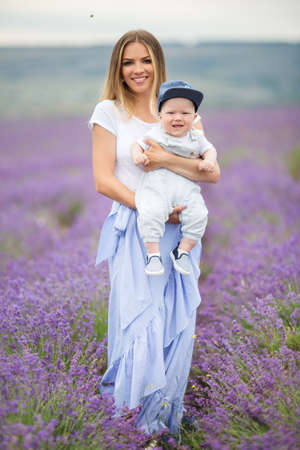 Happy mother and her little son having fun in a lavender fieldの写真素材