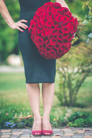 Elegant woman with big bouquet of 101 red roses, date conceptの写真素材