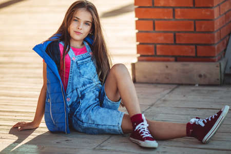 Cute pretty girl is wearing autumn fashion clothes outdoorsの写真素材