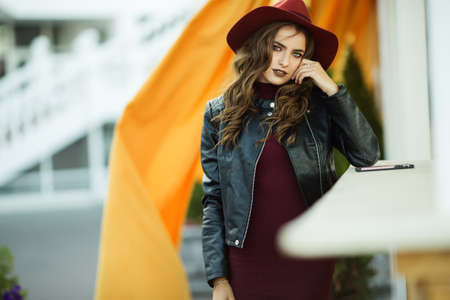 Fashion woman is wearing warm fashion autumn clothes and hat infront walking on the cityの写真素材