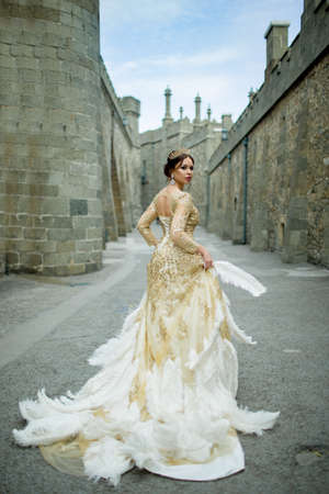 Beautiful sexy woman is wearing princess dress with feathers in the magic castleの写真素材