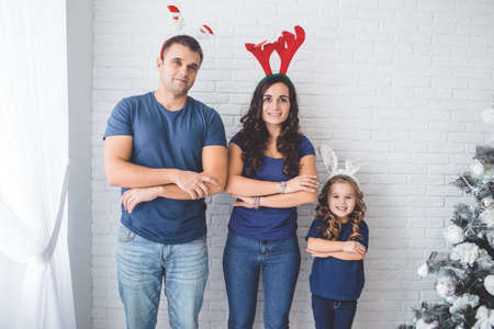 Christmas family photo. Father, mother and daughter are wearing christmas funny horns.の写真素材
