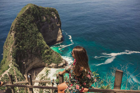 Pretty girl is traveling on kelingking bay, the island of Nusa Penida, Indonesiaの写真素材