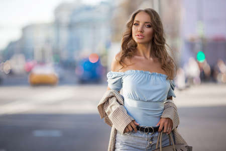 Beautiful young woman wearing stylish clothes walking on the streetの写真素材