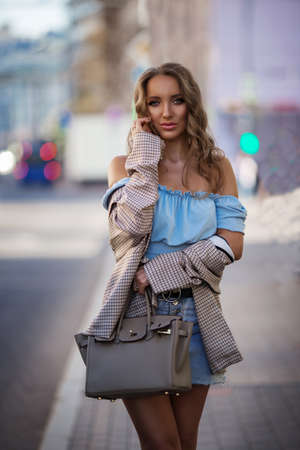 Beautiful young woman wearing stylish clothes walking on the streetの写真素材