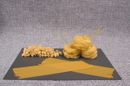 Set of dry pasta. Collection of a variety of raw pasta. Dry macaroni in various shapes, pasta, farfalle, spaghetti.の写真素材