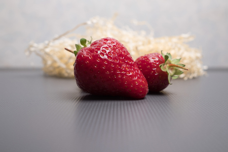 Strawberries on a gray background. Fresh strawberries with leaves. Juicy, natural strawberries.の写真素材
