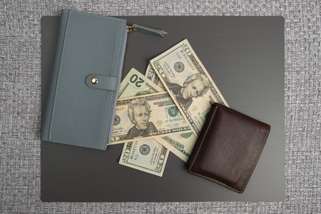 Dollar bills on gray background. Men's leather wallet with dollar bills. Women's gray leather wallet.の写真素材