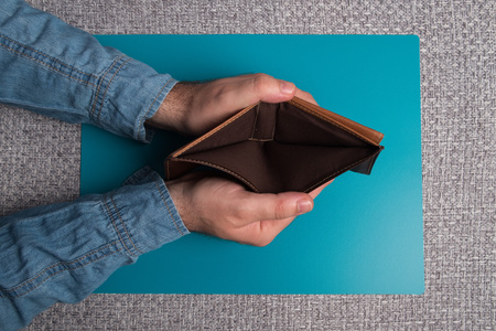 Empty men's wallet studio image. Men's hands holding an empty leather wallet.の写真素材