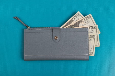 Women's leather wallet studio image. Gray womens wallet with banknotes. Dollar bills. Dollars in a wallet.の写真素材