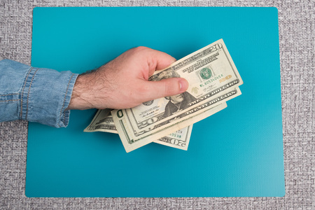 Dollar bills studio image. Male hand holds dollar bills. Money in the male hand.の写真素材