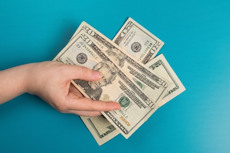 Dollar bills studio image. Female hand holds dollar bills. Money in the female hand.