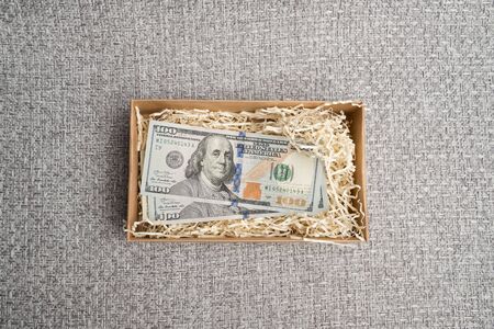 Dollar studio image. Notes in a carton box. Cardboard box with american money. Banknotes in a small...
