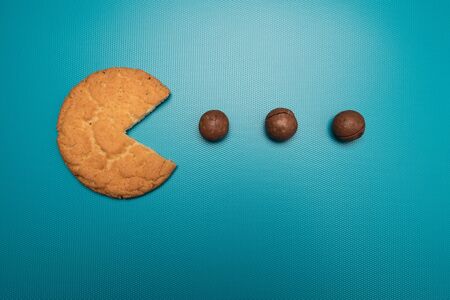 Biscuits and macadamia nuts studio image. Concept cookie eats nuts on the principle of an old computer game.の写真素材