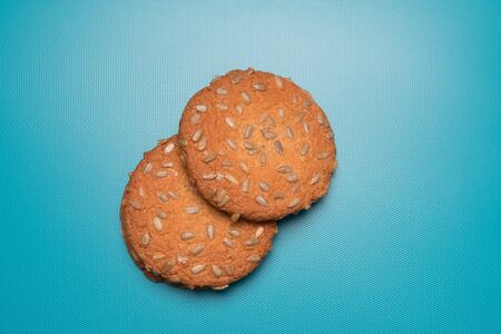 Cookies studio image. Appetizing tasty cookies with seeds. Homemade cookies with sunflower seeds on a blue background.の写真素材