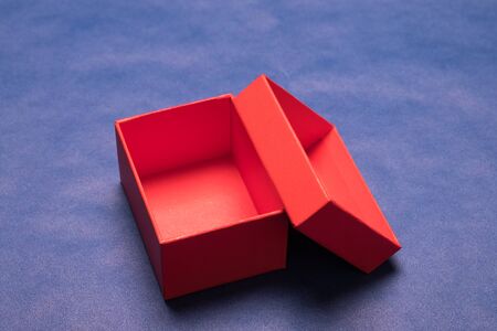 Gift box studio image. Red gift box on a blue background. Empty gift box.の写真素材